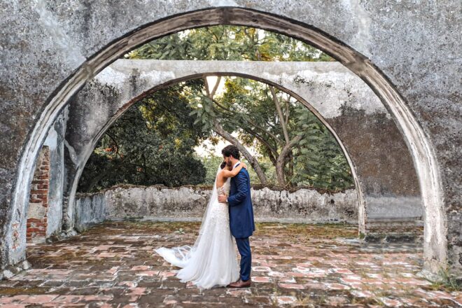 Novios abrazados bajo arco Novios abrazados bajo arco