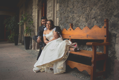 Novios en banca posando vestidos para boda Novios en banca posando vestidos para boda
